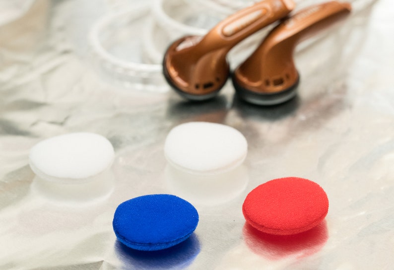 K&ouml;nnte beinhalten: Drei Paar Ohrst&ouml;psel in Wei&szlig;, Blau und Rot. Die St&ouml;psel sind aus Schaumstoff und so konzipiert, dass sie bequem im Ohr sitzen.
