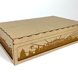 May include: A brown cardboard box with a cutout design of a city skyline and the words "MARVEL CHAMPIONS" on the front.