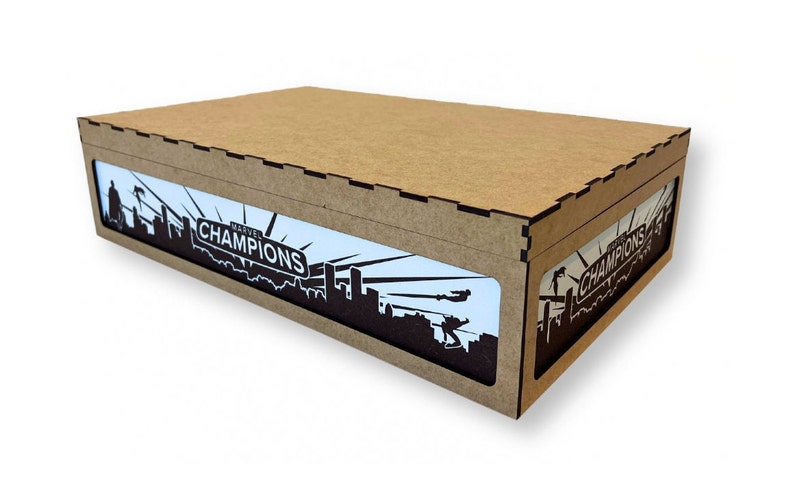 May include: A brown cardboard box with a cutout window showing a black and white graphic of a city skyline with the text "Marvel Champions" on a white background.