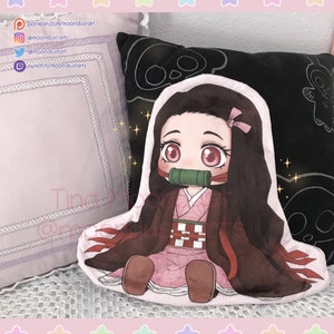 May include: A pink and white plush pillow with a chibi anime character design. The character has long black hair, pink eyes, and is wearing a red and white kimono with a green mouth guard. The pillow is sitting on a purple pillow with white trim.
