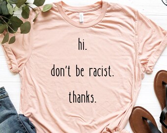 May include: A peach colored t-shirt with the text "hi. don't be racist. thanks." printed in black.