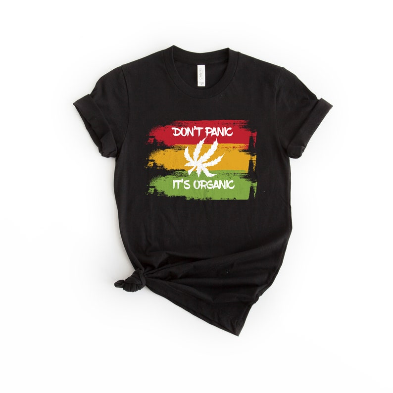 May include: Black t-shirt with a white graphic of a marijuana leaf and the text "Don't Panic It's Organic" in a red, yellow, and green color scheme.