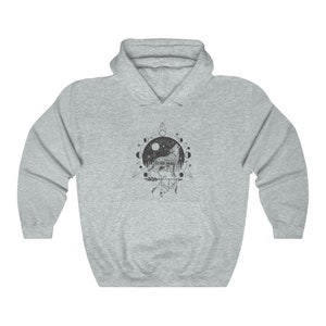 Pode incluir: Uma camisa de frio com capuz cinza com uma estampa gr&aacute;fica de um lobo uivando para a lua. O lobo est&aacute; rodeado por um c&iacute;rculo de luas e estrelas, e um tri&acirc;ngulo com penas e contas.