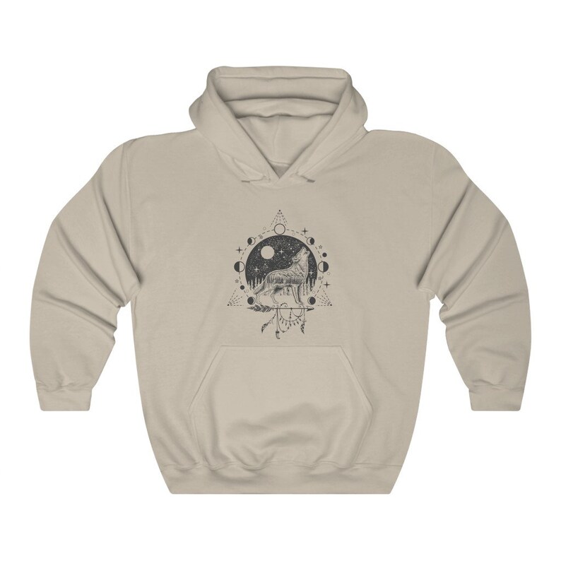 Pode incluir: Uma camisa de moletom com capuz bege com uma estampa gr&aacute;fica em preto e branco de um lobo uivando para a lua. O gr&aacute;fico tamb&eacute;m inclui um c&iacute;rculo de luas, estrelas e um tri&acirc;ngulo.