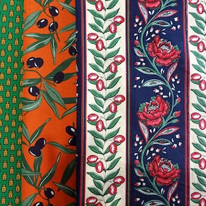 Könnte beinhalten: Drei Stoffmuster mit verschiedenen Mustern. Das erste Muster ist grün mit einem sich wiederholenden Muster aus kleinen goldenen Formen. Das zweite Muster ist orange mit einem sich wiederholenden Muster aus Olivenzweigen und schwarzen Oliven. Das dritte Muster ist blau mit einem sich wiederholenden Muster aus roten Blumen und grünen Blättern.