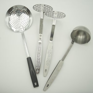 May include: Four silver kitchen utensils: a slotted spoon, a potato masher, a ladle, and a smaller slotted spoon.