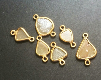 May include: Six gold-toned metal charms with clear, faceted stones. Each charm has two loops for attaching to jewelry.