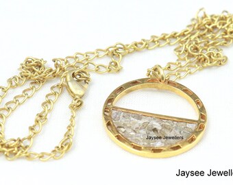 May include: A gold chain necklace with a round pendant. The pendant is made of gold and has a clear, textured center. The text "Jaysee Jewellers" is visible on the pendant.