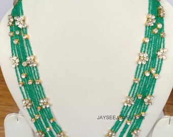 Puede incluir: Un collar de múltiples hilos con cuentas verdes y detalles de diamantes de imitación transparentes. El collar presenta un diseño floral y está acentuado con oro.