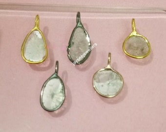 May include: Five silver and gold pendants with clear quartz stones. The pendants are in various shapes, including teardrop and round. The stones are set in a bezel setting.