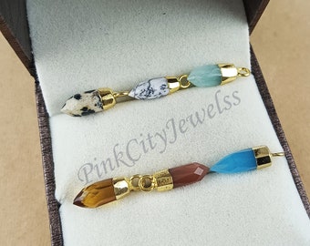 May include: Two gemstone pendants with gold-colored metal accents. One pendant features a spotted stone, a white and black stone, and a light blue stone. The other pendant has a brown stone, a reddish-brown stone, and a blue stone.