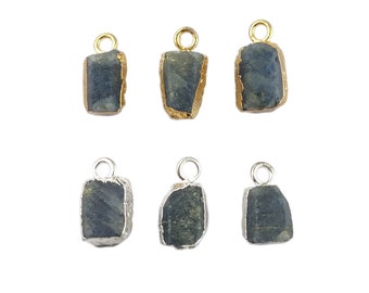 Può includere: Sei ciondoli grezzi in pietra preziosa blu-grigio con accenti metallici color oro e argento. I ciondoli hanno una forma rettangolare con bordi irregolari. Ogni ciondolo ha un piccolo anello nella parte superiore.