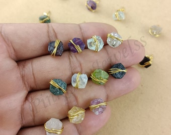 Puede incluir: Surtido de 14 colgantes de piedras preciosas en bruto envueltos en alambre dorado. Las piedras preciosas son de varios colores, incluyendo transparente, verde, morado, rojo y negro.