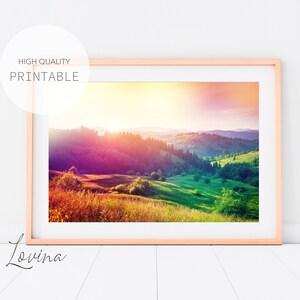 May include: A colorful landscape photograph featuring a sunrise over rolling green hills and a forest. The sky is a vibrant mix of pink, orange, and yellow.