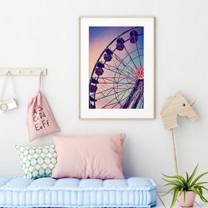 Puede incluir: Una fotograf&iacute;a enmarcada de una noria silueteada contra un cielo de puesta de sol colorido. La noria tiene g&oacute;ndolas iluminadas y se sit&uacute;a sobre un fondo de cielo morado, rosa y azul.