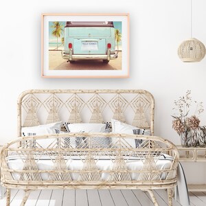 Pode incluir: Uma van azul vintage com uma placa que diz "HELLO SUMMER" estacionada em uma praia com palmeiras ao fundo.