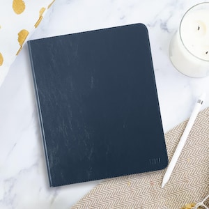 May include: A dark blue leather-bound notebook with the word "fifty" embossed on the front cover.