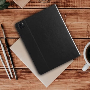 May include: Black leather case for a tablet or iPad. The case has a flap that folds over to protect the screen.