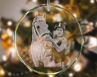 May include: A clear glass bauble with an engraved photo of a person wearing a riding helmet and a horse.