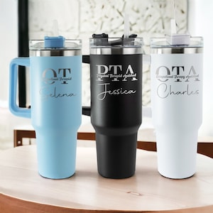 Pu&ograve; includere: Tre tazze da viaggio in acciaio inossidabile con manici e coperchi. Le tazze sono blu, nere e bianche. Ogni tazza ha un'iscrizione diversa: "OT Occupational Therapist Selena", "PTA Physical Therapist Assistant Jessica" e "OTA Occupational Therapy Assistant Charles".