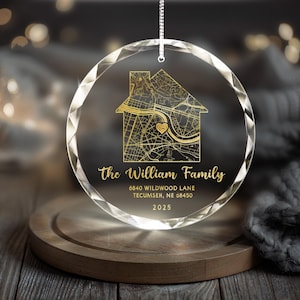 May include: A clear, round glass ornament with a house-shaped map design in gold. The ornament features the text "The William Family," address, and year 2025. It hangs from a silver chain, perfect for holiday decor.