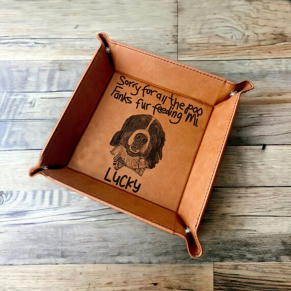 A leather valet tray with your pet's photo engraved into it — the dog-dad angle is specific, emotionally resonant, and genuinely differentiated from the sea of plain monogram trays.