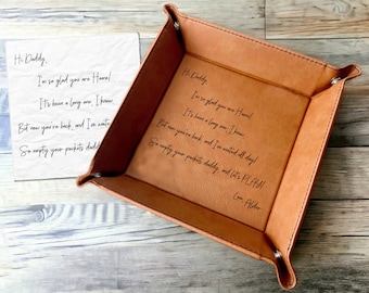 May include: A brown leather valet tray with a handwritten message that reads: "Hi Daddy. I'm so glad you are Home. It's been a long one, I know. But now you're back, and I've waited all day! So empty your pockets daddy, and let's play! Love, Alder"