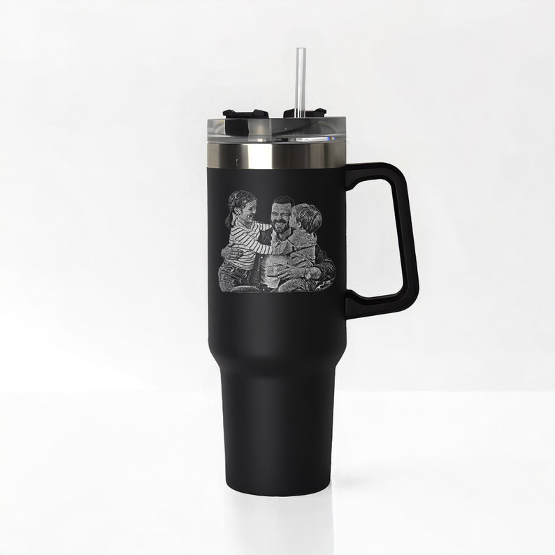 May include: Black stainless steel travel mug with a handle and a straw. The mug has a laser engraved image of a father and two children.