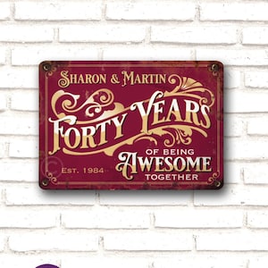 May include: A red metal sign with gold lettering that reads "Sharon & Martin Forty Years of Being Awesome Together Est. 1984".