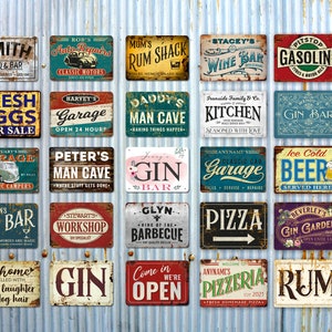 May include: A collection of 20 vintage-style metal signs with various designs and text. The signs feature a variety of themes, including bars, garages, kitchens, and more. The signs are all rectangular and have a distressed, rusty look.