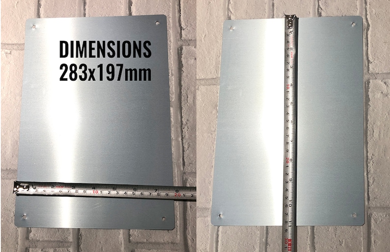 May include: A silver metal sign with rounded corners and four holes for hanging. The sign has the text "DIMENSIONS 283x197mm" printed in black.