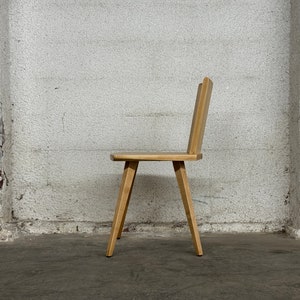 Sculptural solid wood slab chair, composed of three slabs of solid wood, 4 legs, and a satin brass connector