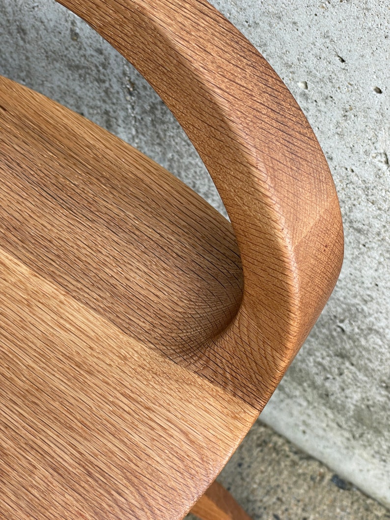 detail photo of modern swivel counter stool with tractor seat showing the flowing hand-sculpted curves, made of solid oak, made in the USA by Marco Bogazzi
