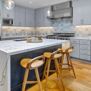 photo of three modern swivel counter stool surrounding a modern kitchen island, made of solid oak, made in the USA by Marco Bogazzi