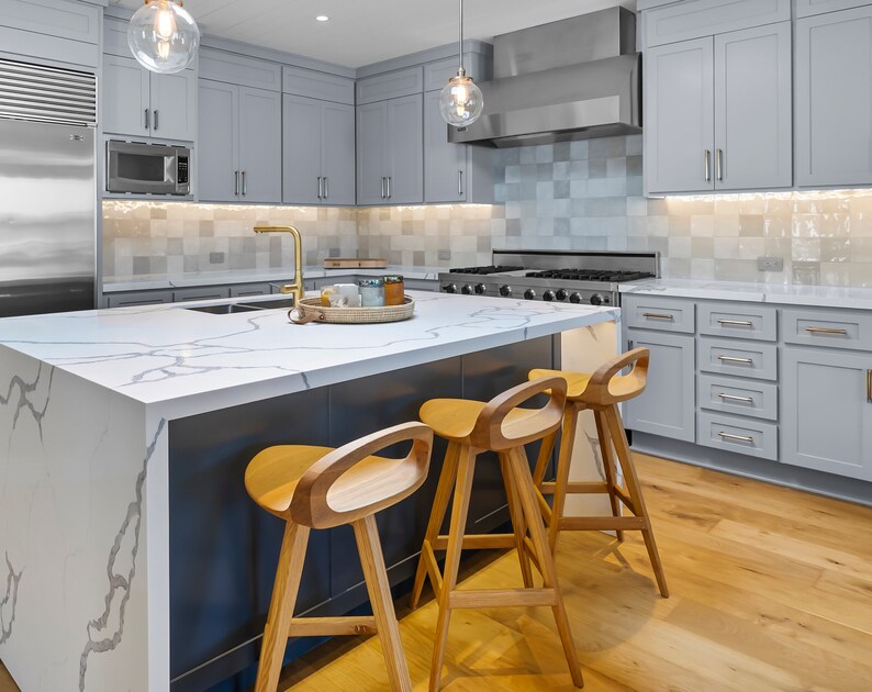 photo of three modern swivel counter stool surrounding a modern kitchen island, made of solid oak, made in the USA by Marco Bogazzi