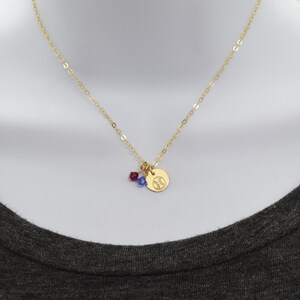 May include: A gold chain necklace with a small gold charm featuring a baseball design. The charm is accented with a red and blue crystal.