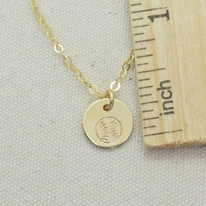 May include: A gold chain necklace with a small gold pendant featuring a baseball design. The pendant is about 1/2 inch in diameter.