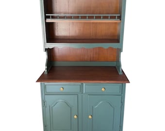 Vitrina de dos piezas en madera maciza, color albahaca y castaño, ideal para la cocina o el comedor.