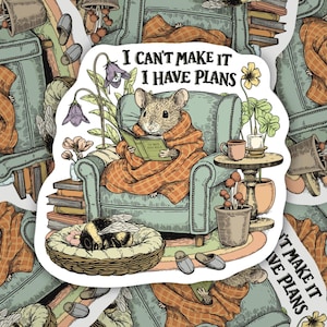 May include: A sticker with an illustration of a mouse reading in an armchair, wrapped in a blanket. The text "I can't make it I have plans" is displayed. A sleeping bee, books, and plants complete the scene, creating a cosy atmosphere.