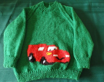 Hand knitted jumper featuring a big red car with a smiley face, made to order and available sizes 2 to 6