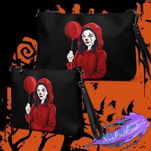 May include: Black clutch bags featuring a graphic of a person in a red hoodie holding a red balloon, with clown-like makeup. The bags have a wrist strap and a zipper closure. The background is black and orange.