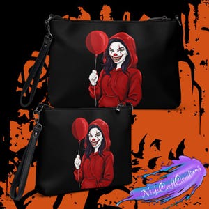 May include: Black clutch bags with a wrist strap, featuring a graphic of a clown holding a red balloon. The clown wears a red hoodie and has white face paint with a sinister smile. The bags are a Halloween theme.