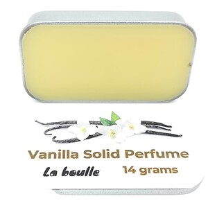 May include: A small silver tin with a yellow solid perfume inside. The tin is labeled "Vanilla Solid Perfume La Bouille 14 grams".