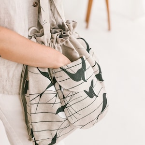 Leinen Bucket Bag mit Schwalben • Handgemachte Boho Tasche • Kordelzug Lock Schultertasche • Tasche mit großer Fronttasche