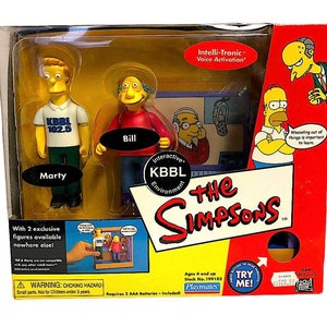 May include: A packaged set of "The Simpsons" action figures, including Marty and Bill, themed around the KBBL radio station. The box features the text "Intelli-Tronic Voice Activation" and "Interactive KBBL Environment."