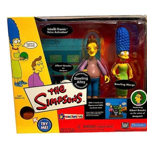 May include: A Simpsons toy set with Jacques and Bowling Marge figures. The packaging features the text "Intelli-Tronic Voice Activation" and "Interactive Bowling Alley Environment". The box is yellow and red with the Toys R Us exclusive logo.