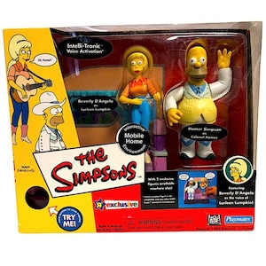 May include: A Simpsons toy set featuring two figures: Beverly D'Angelo as Lurleen Lumpkin and Homer Simpson as Colonel Homer. The packaging includes the show's logo and the text "Interactive Mobile Home Environment."