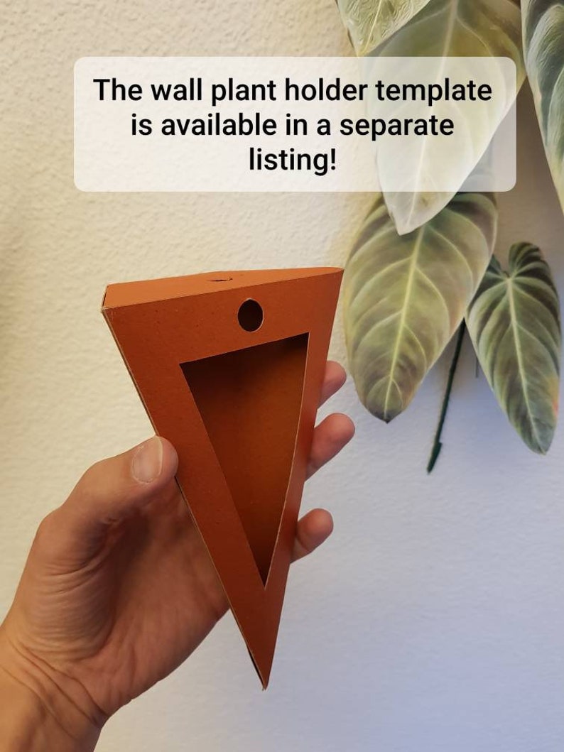 Pu&ograve; includere: Un modello di supporto a parete triangolare arancione per piante, con un ritaglio e un foro circolare. Il testo sull'immagine recita: "Il modello di supporto a parete &egrave; disponibile in un annuncio separato!"