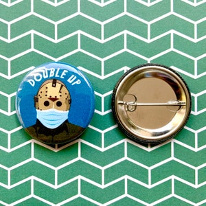 May include: A blue and white button with the text "Double Up" and a graphic of a hockey mask wearing character. The button is on a green and white patterned background.