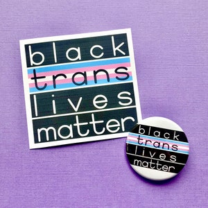 Puede incluir: Bot&oacute;n blanco y negro con el texto "black trans lives matter" en negro con un patr&oacute;n de rayas rosa, azul y blanco.